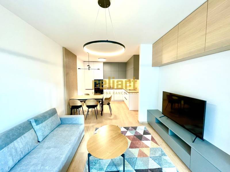 Bory:Na prenájom úplne nový, elegantný 2i byt/eng.text inside - Obývacia izba s pohovkou, jedálenským stolom a TV, podlaha s dreveným dekorom, 2-izbový byt.