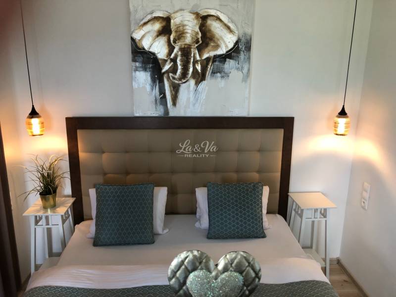 Na predaj štyri apartmány na jednom poschodí Podhájská - Spálňa so štýlovým osvetlením a obrazom slona v 2-izbovom byte.