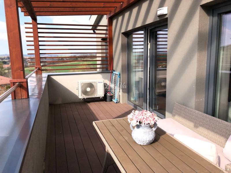 Na predaj štyri apartmány na jednom poschodí Podhájská - Terasa 2-izbového bytu s výhľadom na okolie a kvetinovou dekoráciou.