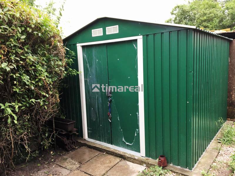 Bývanie v prírode, na dosah mesta, murov. chatka s celoročným využitím - Záhrada pri rodinnom dome v Bohdanovciach nad Trnavou s plechovým zeleným záhradným domčekom.