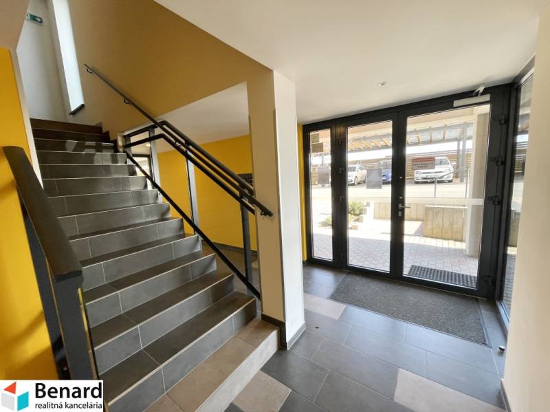 KOŠICE-2 IZBOVÝ BYT,NOVOSTAVBA,KOMPLET ZARIADENÝ,VL.PARK. MIESTO - Schodisko s tmavými obkladačkami a presklenými dverami v Košiciach na ulici Borievkova.