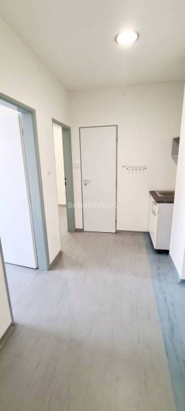Dobré reality-na prenájom priestory 48,4 m2 a 30,90m2+ kúpelňa s wc, p - Interiér kancelárií s laminátovou podlahou a bielymi stenami, kuchynská linka v rohu.
