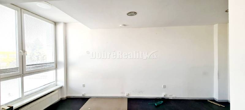 Dobré reality-na prenájom priestory 48,4 m2 a 30,90m2+ kúpelňa s wc, p - Biele steny s veľkým oknom a podlahou v dekore dreva v kancelárii.