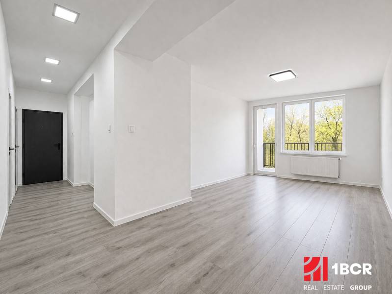 NOVÁ KOMPLET. REK., 3–IZB. BYT, PIVNICA, BALKÓN, DUKELSKÁ, BERNOLÁKOVO - Svetlý interiér 3-izbového bytu s podlahou s dreveným dekorom a veľkými oknami.