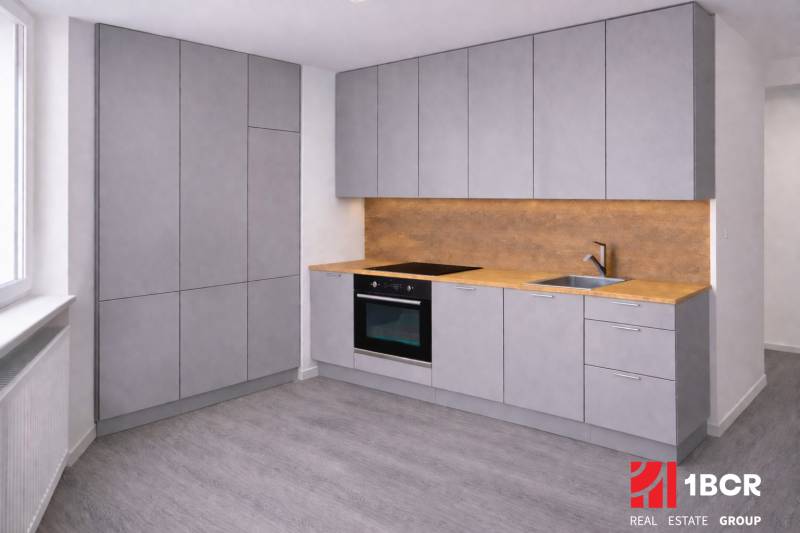 NOVÁ KOMPLET. REK., 3–IZB. BYT, PIVNICA, BALKÓN, DUKELSKÁ, BERNOLÁKOVO - Kuchyňa so šedými skrinkami, dreveným dekorom podlahy a osvetlením do 3-izbového bytu.