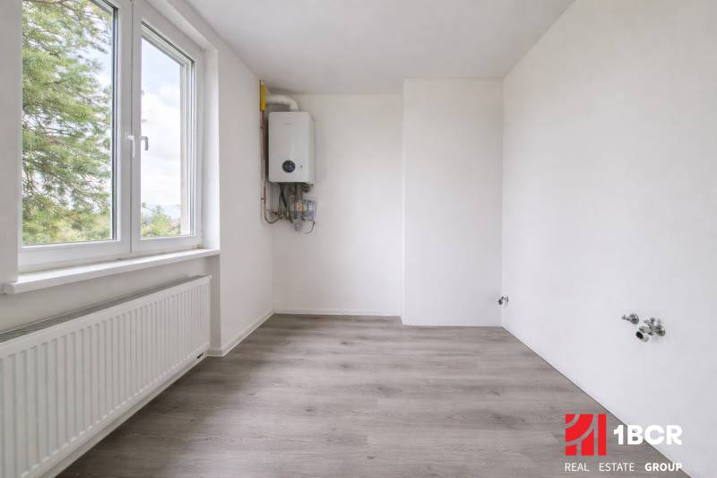 NOVÁ KOMPLET. REK., 3–IZB. BYT, PIVNICA, BALKÓN, DUKELSKÁ, BERNOLÁKOVO - Izba s bielymi stenami a podlahou s dreveným dekorom v 3-izbovom byte.