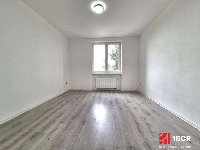 NOVÁ KOMPLET. REK., 3–IZB. BYT, PIVNICA, BALKÓN, DUKELSKÁ, BERNOLÁKOVO - Prázdna miestnosť s podlahou s dreveným dekorom a bielymi stenami v 3-izbovom byte.