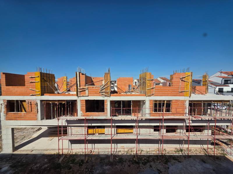 CHORVÁTSKO - Apartmány 40 m od mora vo výstavbe - SRIMA, VODICE - Rozostavaný 3-izbový byt v Srime s červenými tehlami a lešením.