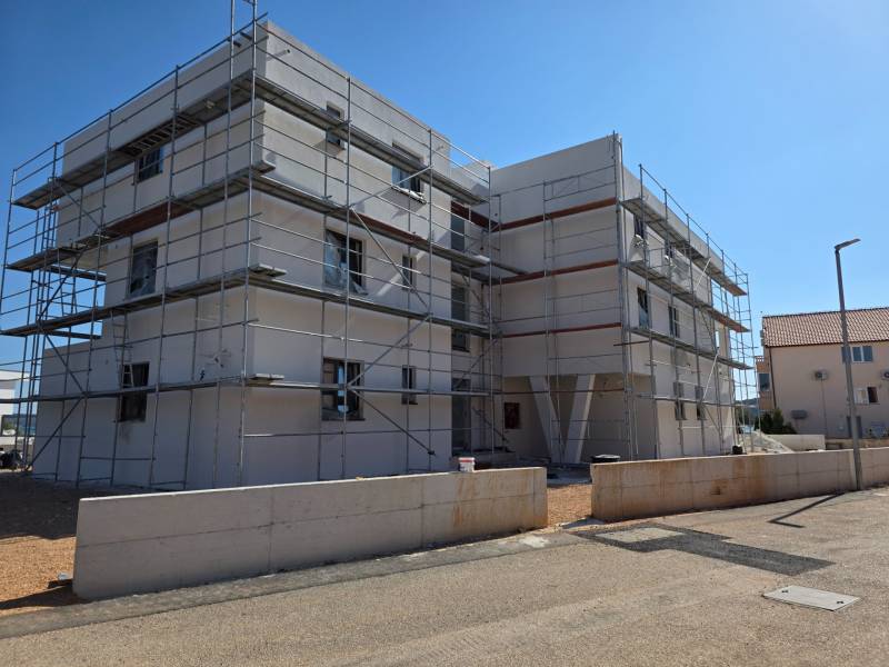 CHORVÁTSKO - Moderné apartmány 80 m od mora - SRIMA, VODICE - Stavebný projekt 3-izbového bytu v SRIMA, obklopený lešením v slnečnom počasí.