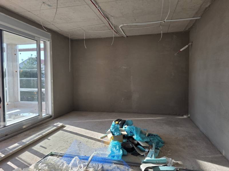 CHORVÁTSKO - Moderné apartmány 80 m od mora - SRIMA, VODICE - Izba v 3-izbovom byte s betónovými stenami a materiálmi na podlahe.