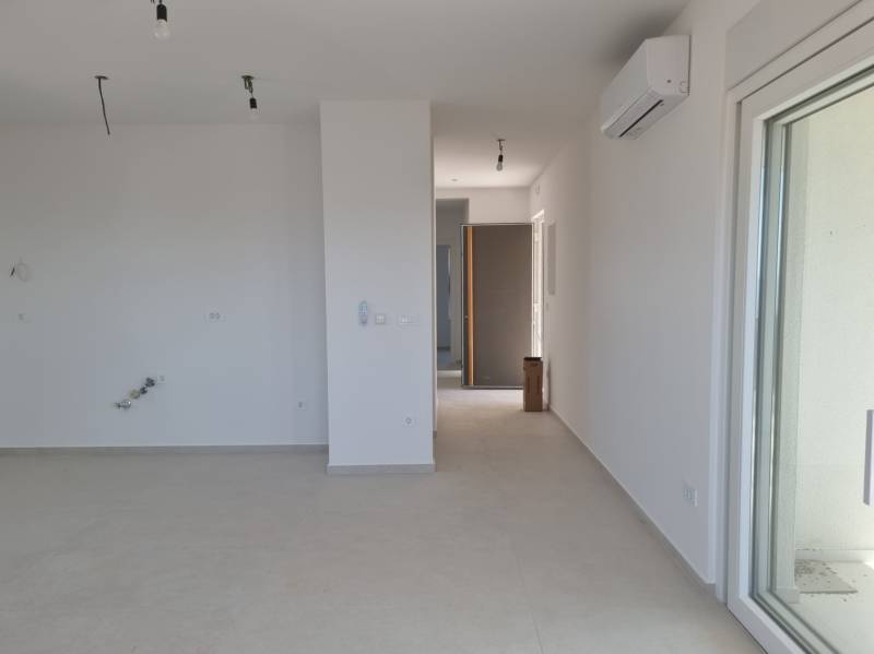 CHORVÁTSKO - 4 izbové apartmány s priestrannými pivnicami - VODICE - Priestranný interiér 4-izbového bytu s bielymi stenami a klimatizáciou.
