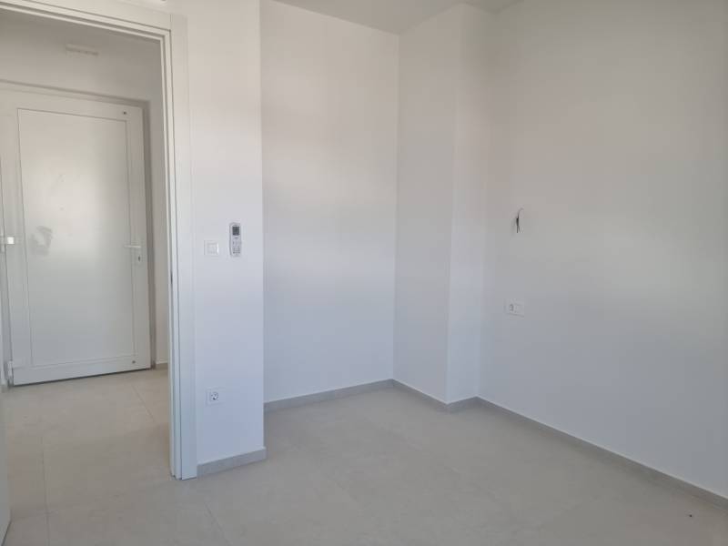 CHORVÁTSKO - 4 izbové apartmány s priestrannými pivnicami - VODICE - Prázdna miestnosť s bielymi stenami a sivou podlahou v 4-izbovom byte.