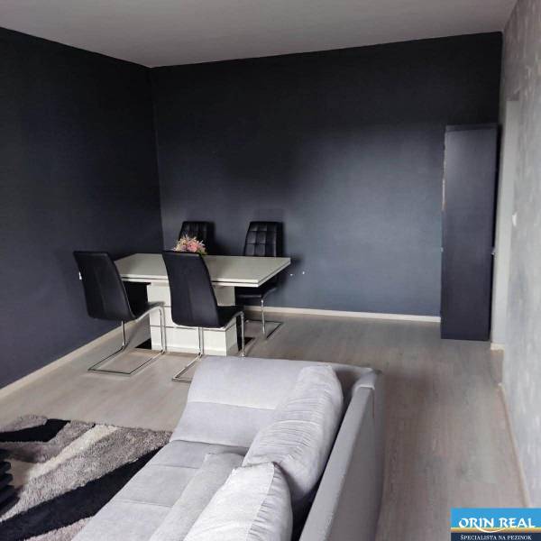 Na prenájom pekný 3izbový byt po rekonštrukcii 800,- Eur - Jedálenská časť s tmavými stenami a podlahou s dreveným dekorom v 3-izbovom byte.