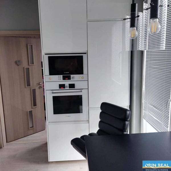 Na prenájom pekný 3izbový byt po rekonštrukcii 800,- Eur - Kuchyňa v 3-izbovom byte so vstavanými spotrebičmi a čiernym stolom.