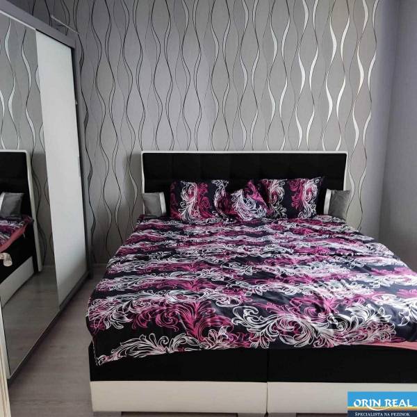 Na prenájom pekný 3izbový byt po rekonštrukcii 800,- Eur - Spálňa v 3-izbovom byte s posteľou a vzorovanými tapetami na stene.
