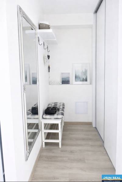 Na predaj 1,5 izbový apartmán v BA III Malokrasňanská 42,34m2 - Vstupná hala v 2-izbovom byte so zrkadlom, lavičkou a podlahou s dreveným dekorom.