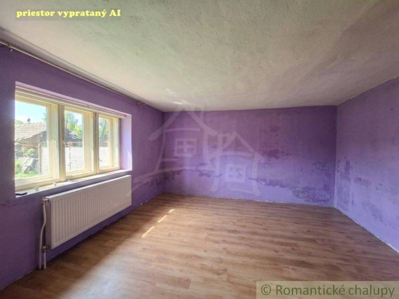 Chalupa na rekonštrukciu v tichom lone Bystričky - Prázdna miestnosť s fialovými stenami v rodinnom dome, podlaha s dreveným dekorom.