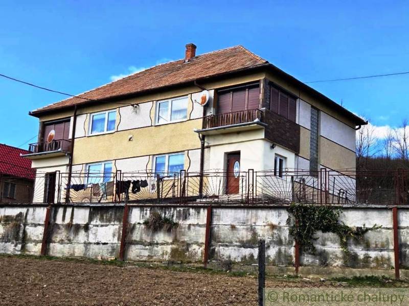 Rodinný dom s 2 bytovými jednotkami, veľkým pozemkom a hospodárskym zá - Rodinný dom v Kiarove s dvoma poschodiami a hnedou strechou.