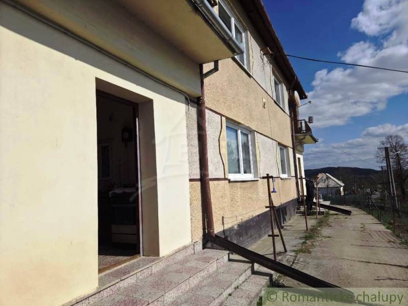 Rodinný dom s 2 bytovými jednotkami, veľkým pozemkom a hospodárskym zá - Rodinný dom v Kiarove so schodiskom a veľkými oknami, na vidieckej ulici.