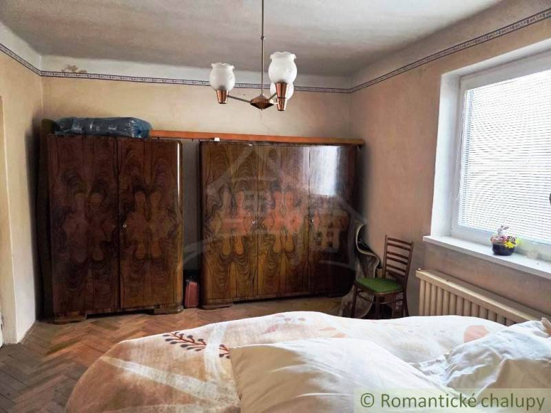 Rodinný dom s 2 bytovými jednotkami, veľkým pozemkom a hospodárskym zá - Interiér rodinného domu s klasickým nábytkom a podlahou s dreveným dekorom.