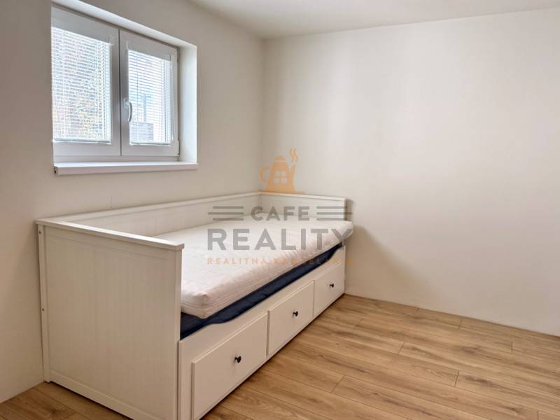 Na predaj 2 izbový murovaný domček, Bratislava, Záhorská Bystrica - Spálňa v 2-izbovom byte s posteľou a podlahou s dreveným dekorom.