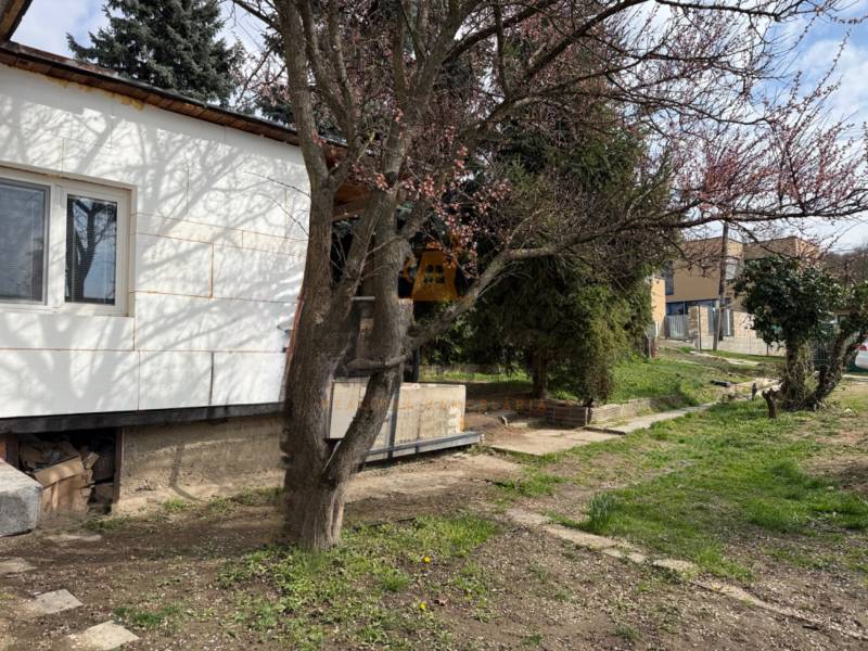 Na predaj 2 izbový murovaný domček, Bratislava, Záhorská Bystrica - Rodinný dom na Podkerepušky v Záhorská Bystrica, obklopený stromami a zeleným trávnikom.