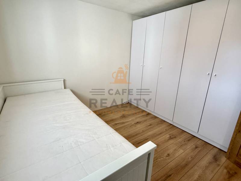 Na predaj 2 izbový murovaný domček, Bratislava, Záhorská Bystrica - Spálňa s posteľou, bielou skriňou a podlahou s dreveným dekorom v 2-izbovom byte.