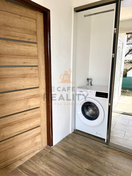 Na predaj 2 izbový murovaný domček, Bratislava, Záhorská Bystrica - Dvere s dreveným dekorom a práčka v 2-izbovom byte.