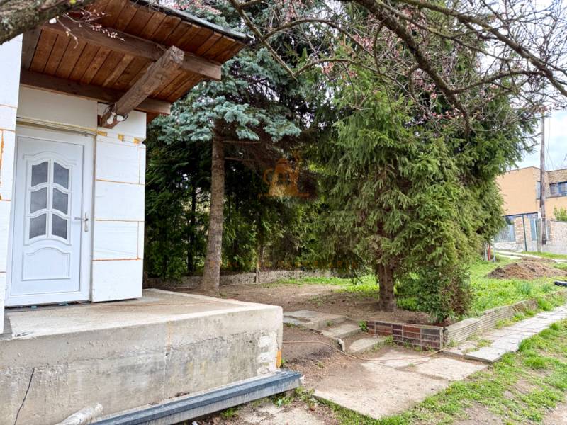 Na predaj 2 izbový murovaný domček, Bratislava, Záhorská Bystrica - Záhrada so stromami a vstupom do budovy na ulici Podkerepušky v Bratislave-Záhorskej Bystrici.