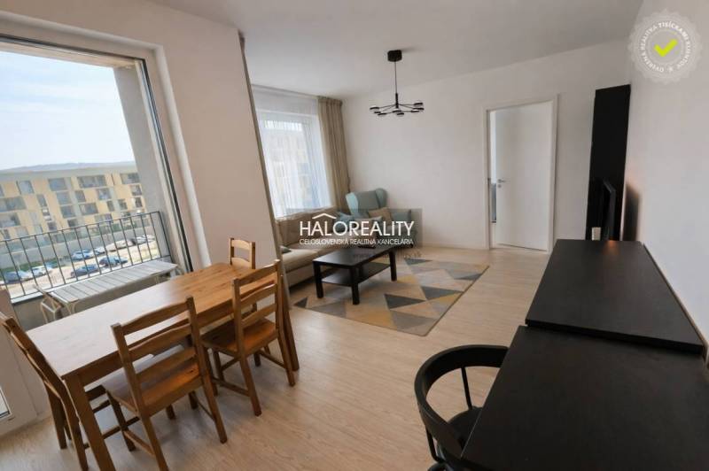 Predaj, dvojizbový byt Bratislava Devínska Nová Ves,... - Obývačka v 2-izbovom byte s balkónom, podlahou s dreveným dekorom, jedálenským stolom.