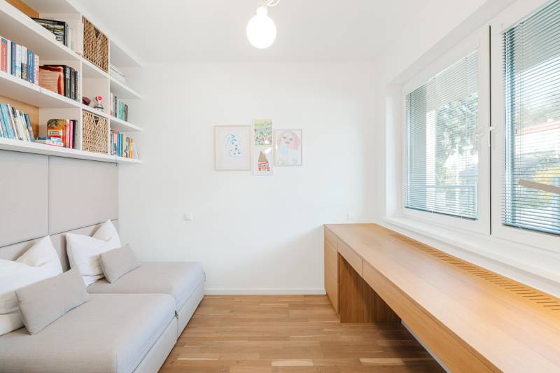 NUERA | PREDAJ 4i byt s predzáhradkou pri lese + 2x parking , BAIV - Svetlá izba s podlahou s dreveným dekorom, pohovkou a veľkými oknami.