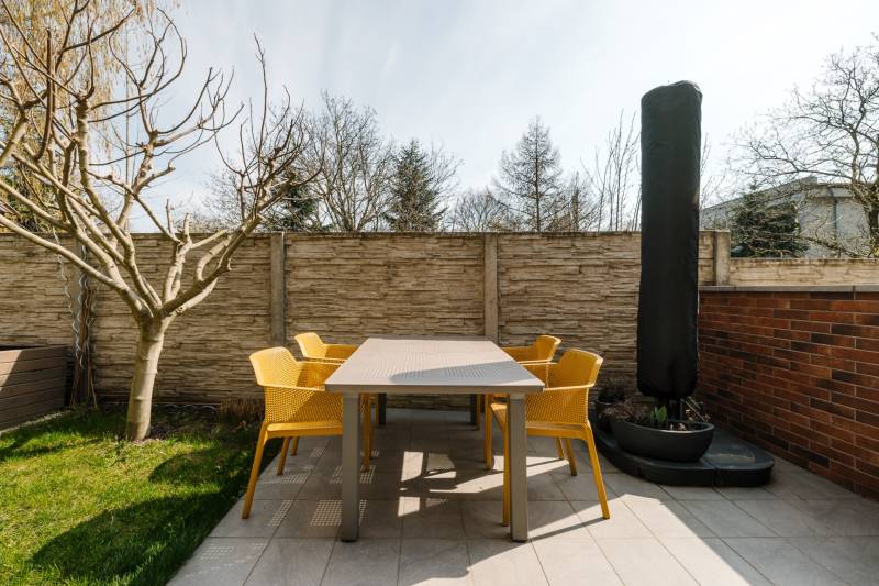 NUERA | PREDAJ 4i byt s predzáhradkou pri lese + 2x parking , BAIV - Terasa 4-izbového bytu na Ceste na Klanec v Lamači, s moderným nábytkom a stromom.