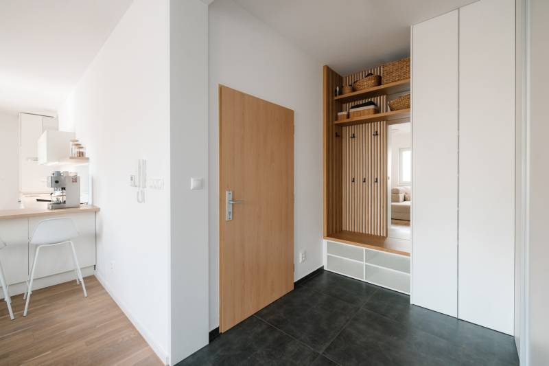 NUERA | PREDAJ 4i byt s predzáhradkou pri lese + 2x parking , BAIV - Vstupná chodba s úložným priestorom, podlaha s dekorom a kuchynský kút v 4-izbovom byte.