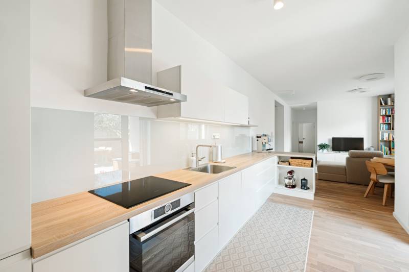 NUERA | PREDAJ 4i byt s predzáhradkou pri lese + 2x parking , BAIV - Kuchyňa v 4-izbovom byte s podlahou s dreveným dekorom a svetlou výbavou.