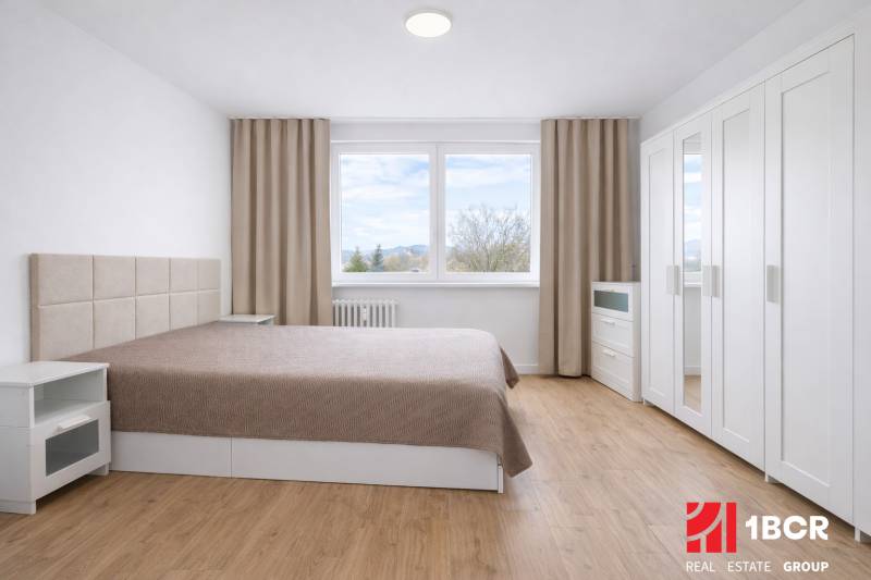NOVO KOMPLET. PREROBENÝ 2 – IZB. BYT, PIVNICA ,LATORICKÁ, BRATISLAVA - Spálňa s manželskou posteľou, skriňou a podlahou s dreveným dekorom v 2-izbovom byte.