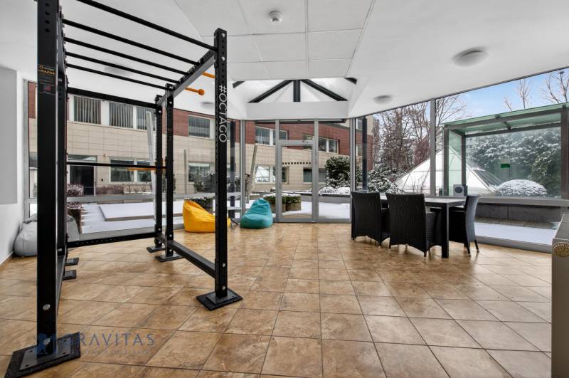 Kancelárie od 20m2 na PRENÁJOM | TOP biznis lokalita - Fitness zariadenie a sedenie s výhľadom v Kancelárii, podlaha s dreveným dekorom.