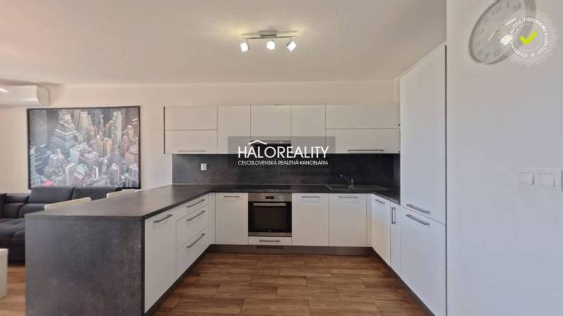 Prenájom, dvojizbový byt Stupava, Cementárenská - NO... - Kuchyňa v 2-izbovom byte s podlahou s dreveným dekorom, bielymi skrinkami a obrazuom.