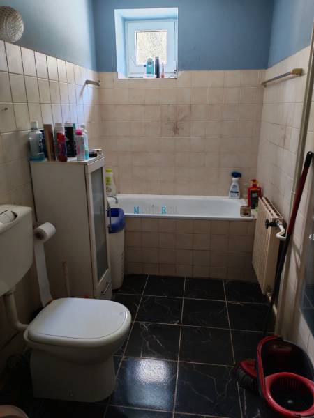 Na predaj 3-podlažný rodinný dom  v blízkosti centra Myjavy  - Kúpeľňa s vaňou a toaletou v rodinnom dome, s tmavou dlažbou a oknom.