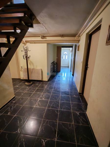 Na predaj 3-podlažný rodinný dom  v blízkosti centra Myjavy  - Interiér s čiernymi obkladovými dlaždicami a schodiskom v rodinnom dome.