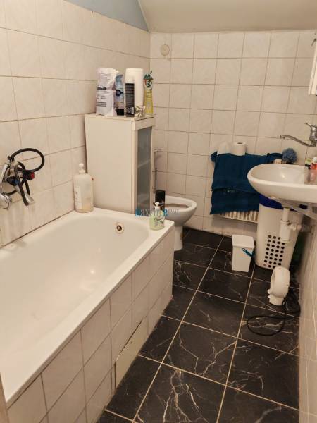 Na predaj 3-podlažný rodinný dom  v blízkosti centra Myjavy  - Kúpeľňa v rodinnom dome s vaňou, umývadlom a dlažbou s tmavým vzorom.