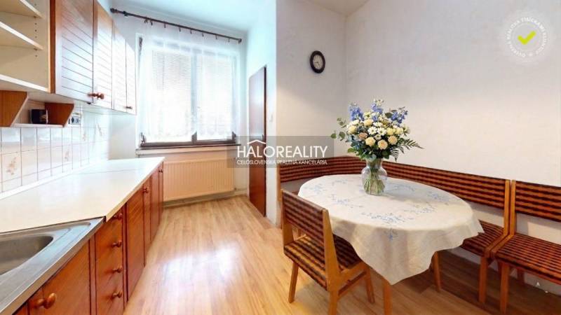 Predaj, rodinný dom Poltár - EXKLUZÍVNE HALO REALITY - Kuchyňa v rodinnom dome s podlahou s dreveným dekorom a kvetinovou výzdobou.