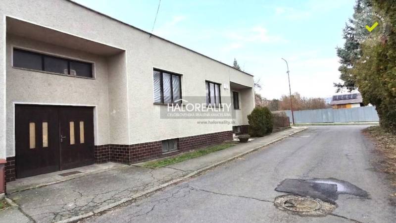 Predaj, rodinný dom Poltár - EXKLUZÍVNE HALO REALITY - Rodinný dom v meste Poltár s rovnou strechou a garážou pri ceste.