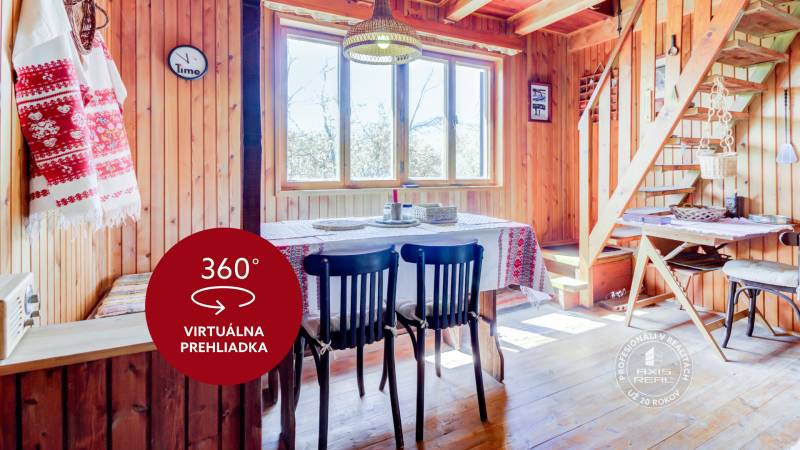Dvojpodlažná chata v krásnom prostredí Buková, okr. Trnava - Drevený interiér chaty s jedálenským stolom, stoličkami, schodmi a tradičnými textíliami.