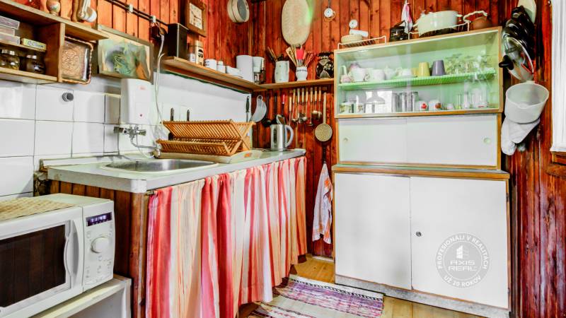 Dvojpodlažná chata v krásnom prostredí Buková, okr. Trnava - Kuchyňa v chate s dreveným obložením, tradičným nábytkom a kuchynským príslušenstvom.