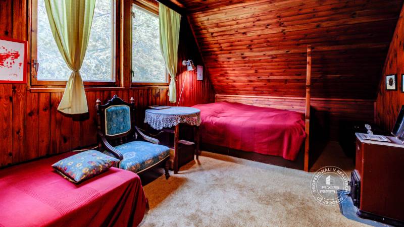 Dvojpodlažná chata v krásnom prostredí Buková, okr. Trnava - Izba v Chate s dreveným obkladom, posteľou a kreslom, príjemná atmosféra na oddych.