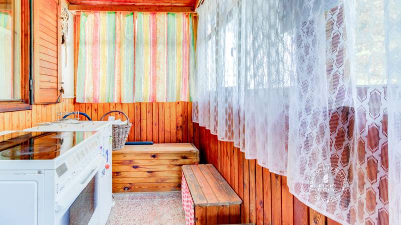 Dvojpodlažná chata v krásnom prostredí Buková, okr. Trnava - Chata s kuchynským kútom, ratanovým košom, dreveným obkladom a pestrofarebnými závesmi.