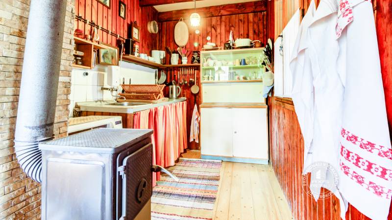 Dvojpodlažná chata v krásnom prostredí Buková, okr. Trnava - Kuchyňa v chate s dreveným obložením, varičom a riadom.