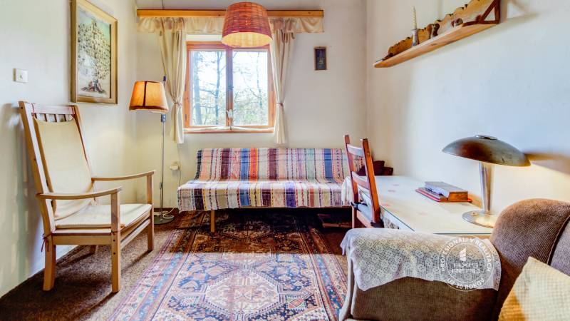 Dvojpodlažná chata v krásnom prostredí Buková, okr. Trnava - Obývacia izba v chate s pohodlným nábytkom, koberec a dekorácie na stene.