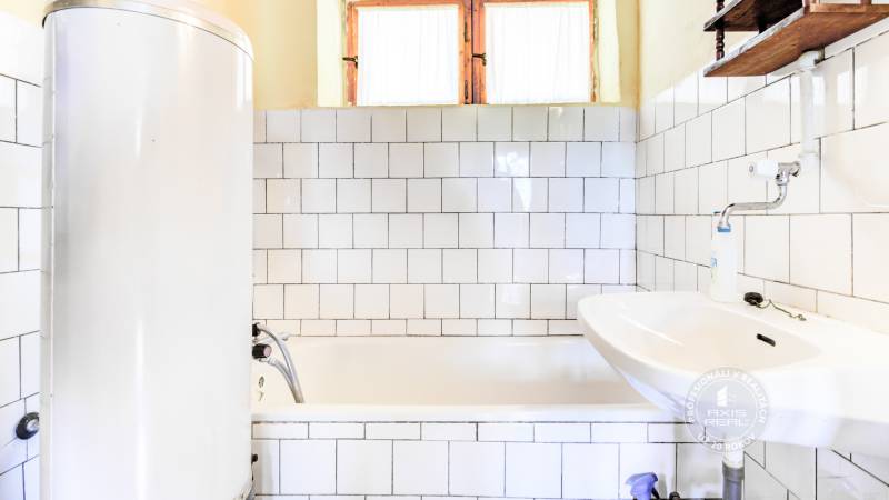 Dvojpodlažná chata v krásnom prostredí Buková, okr. Trnava - Kúpeľňa v chate s vaňou, umývadlom a bojlerom, obložená bielymi kachličkami.