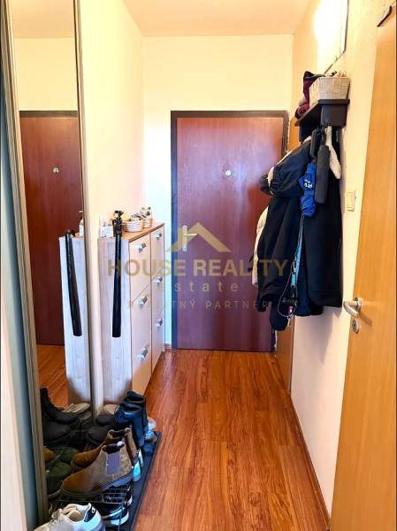 Pekný zariadený 3 izbový byt s lodžiou, Púpavová ulica, BA.Karlova Ves - Vstupná chodba v 3-izbovom byte s podlahou s dreveným dekorom a praktickým nábytkom.